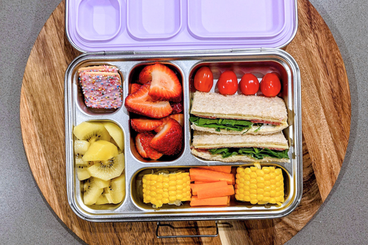Lunchbox with sandwich, fruits, vegetables and sweet treat