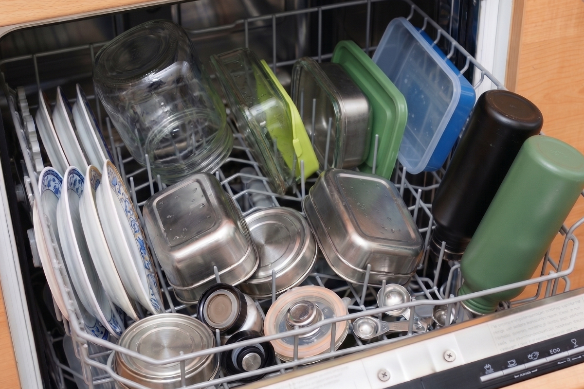 Dishwasher drawer with crockery, glass, stainless steel and plastic containers and aluminium bottles
