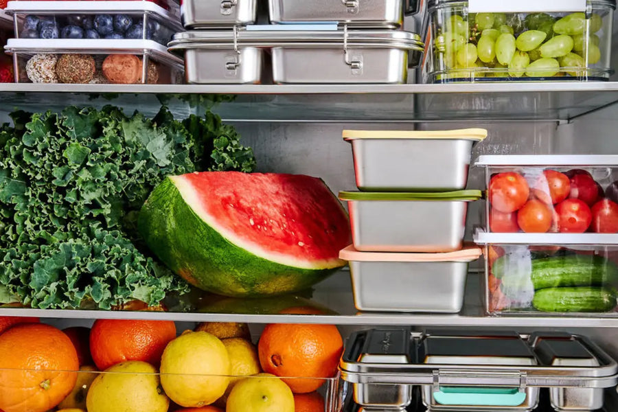 Fridge willed with fresh fruit and vegetables and stainless steel lunch boxes