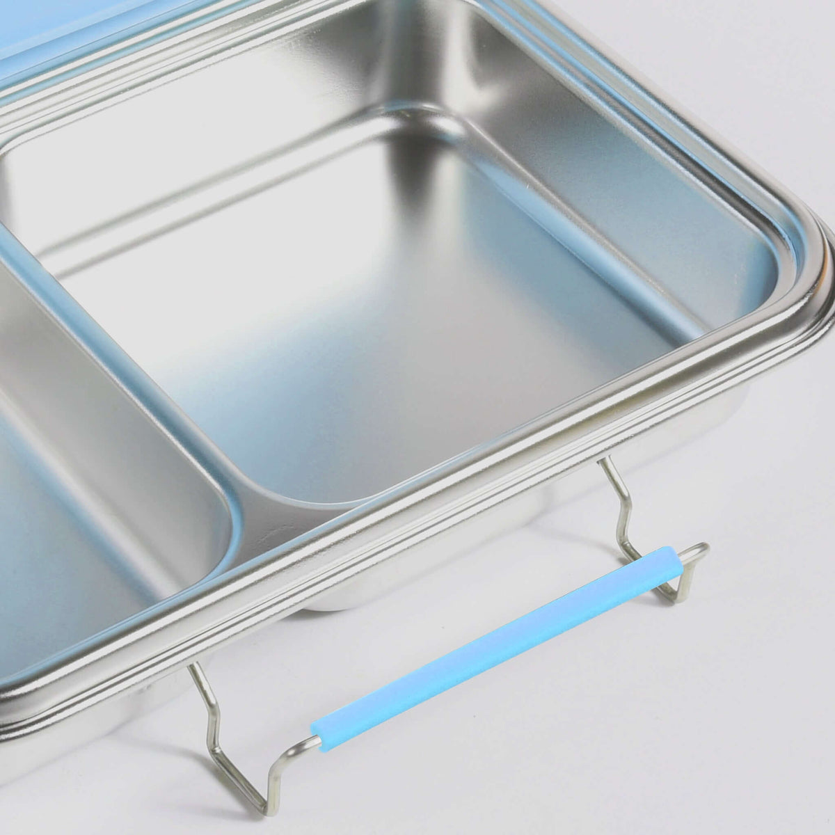 Blue replacement latch fitted to the side of a two-compartment stainless steel bento box