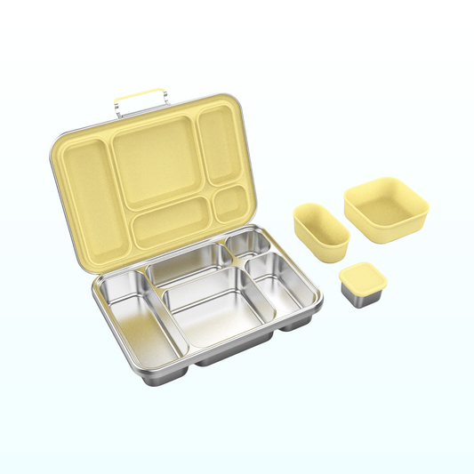Open stainless steel bento lunch box with a pale yellow lid, five compartments and two matching silicone snack cups