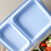 Pale blue replacement silicone seal seated in a two-compartment stainless steel bento lid
