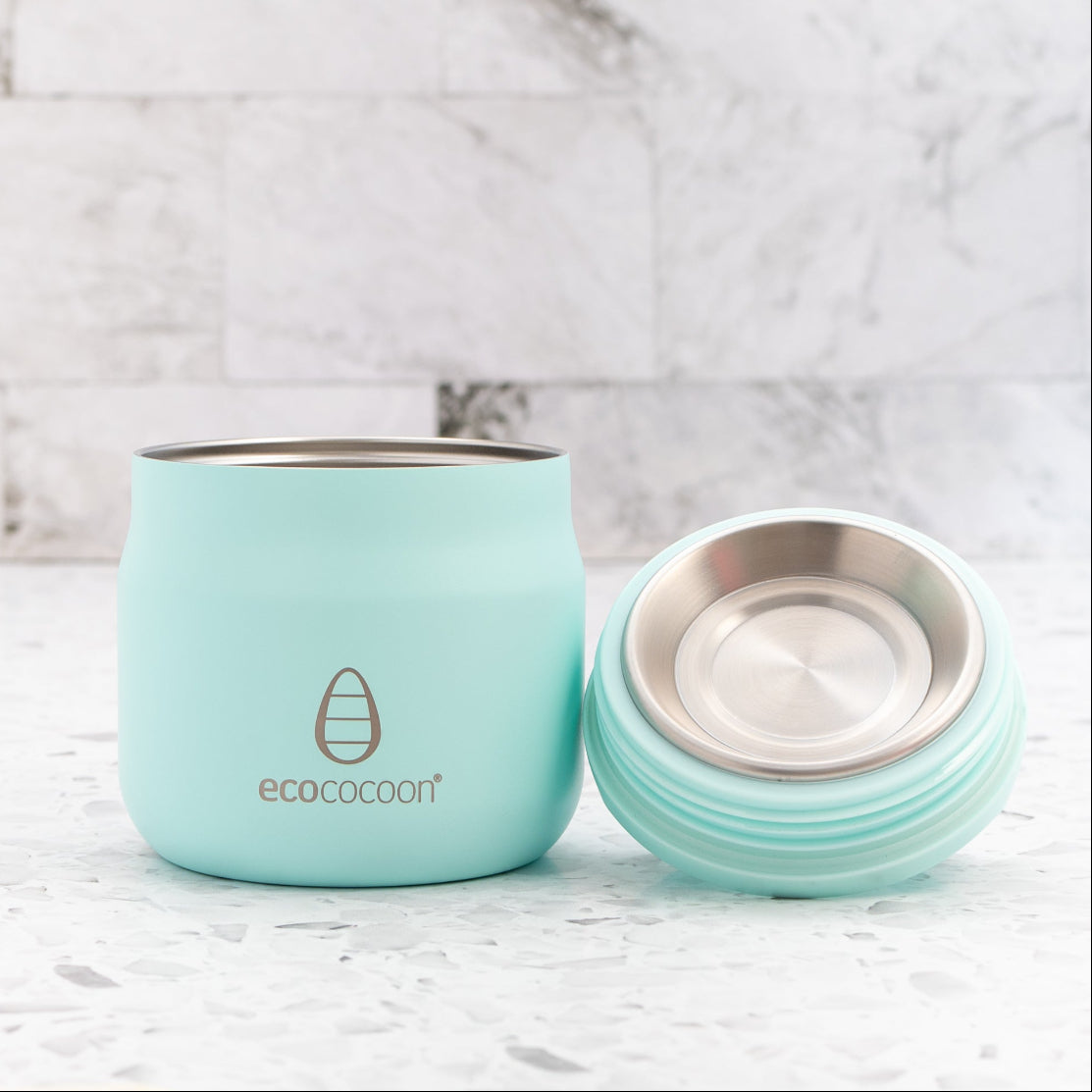 Turquoise reusable coffee cup with lid on a marble background