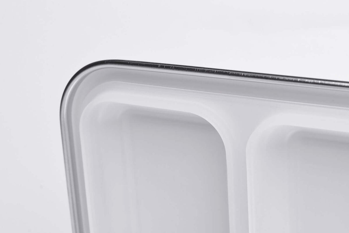 Angled close-up of a white replacement silicone seal for the two-compartment bento lid