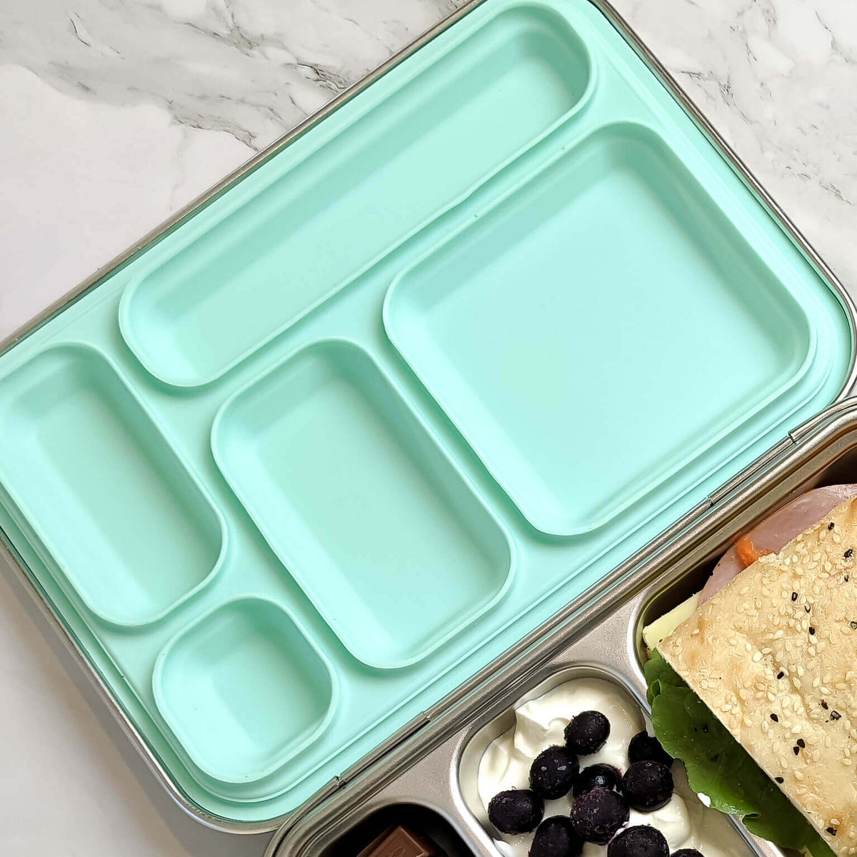 Mint green replacement silicone seal seated in a five-compartment stainless steel bento lid