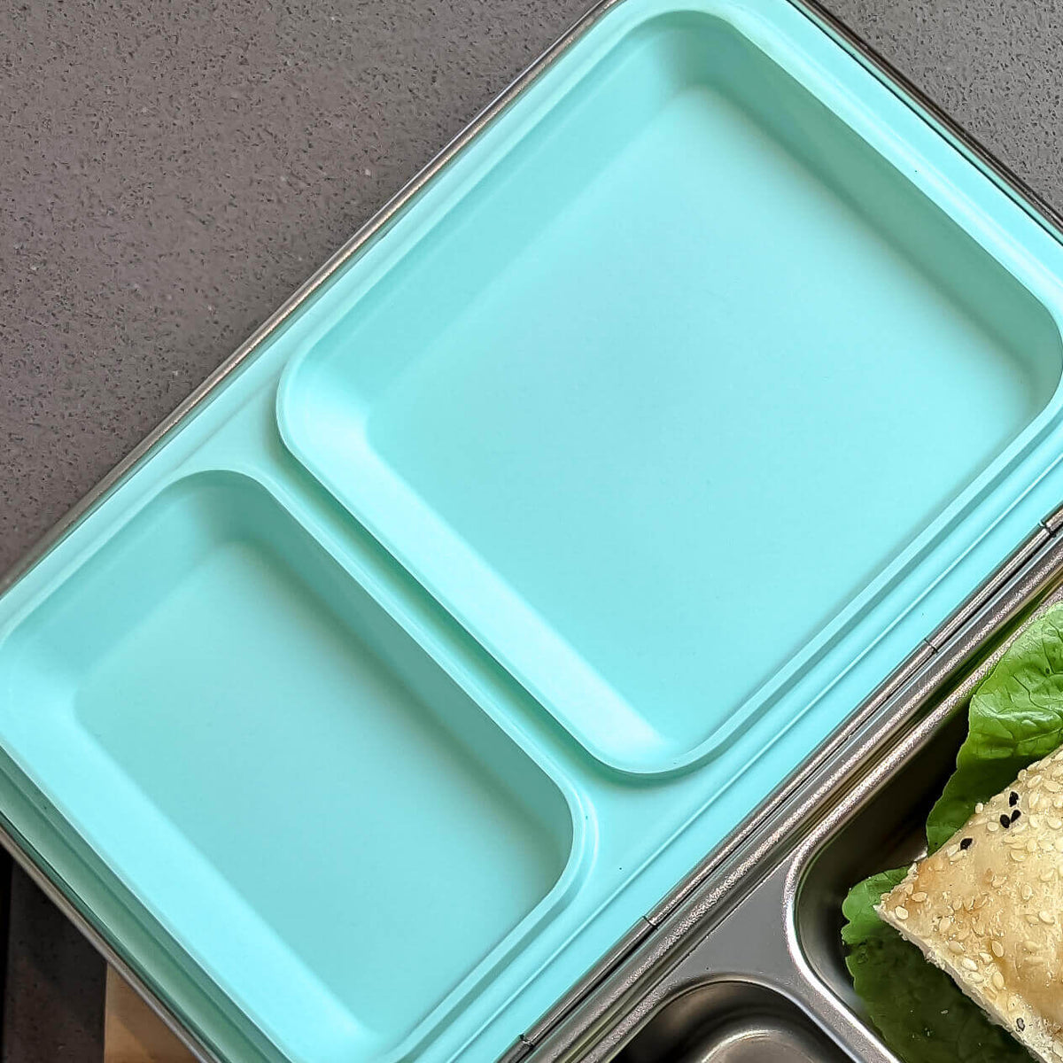 Aqua replacement silicone seal seated in a two-compartment stainless steel bento lid